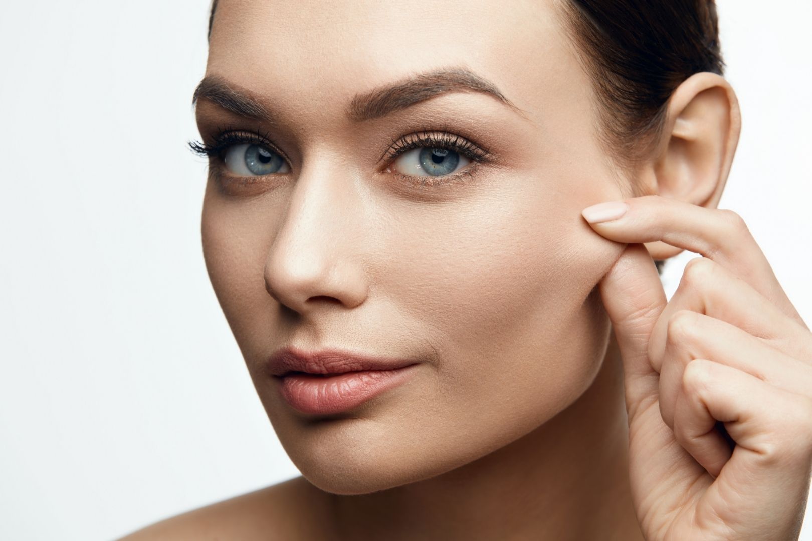 Woman pinching her face to show the elasticity benefits of Vitamin C