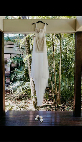 beaded lace wedding dress hanging on door frame