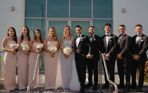 bridal party posing for photos on church steps