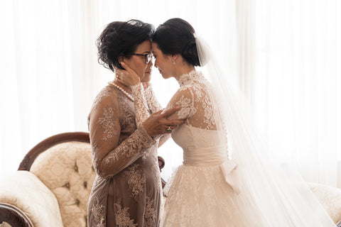 bride and mother of the bride hugging before wedding