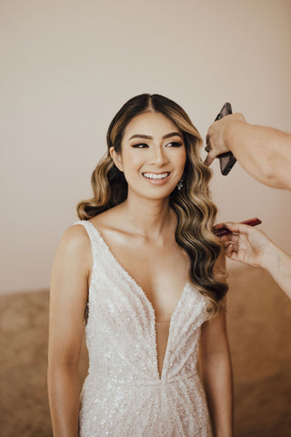 bride having her hair and make up done before wedding