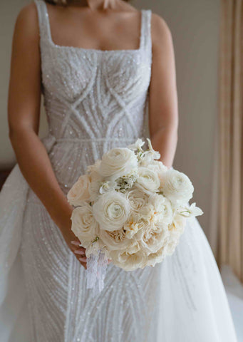 bride holding bouquet of flowers with u-neck wedding dress