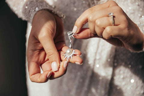 bride holding jewellery on her wedding day