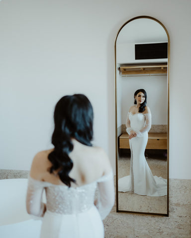bride posing in front of mirror in her custom wedding dress