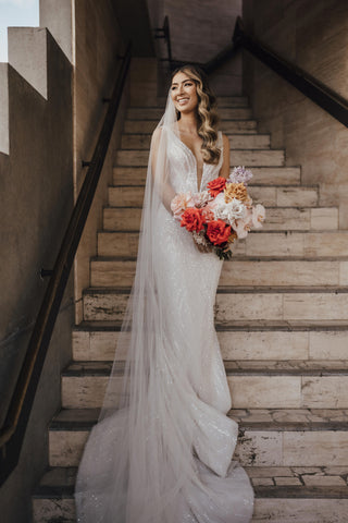 bride standing on staircase with bouquet of flowers