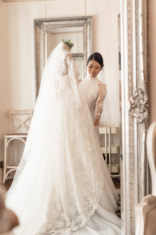 bride taking her wedding dress off a dressform before her wedding day