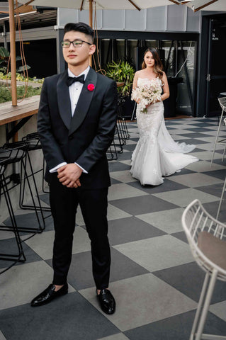 bride walking up behind her husband wearing wedding dress for the first look