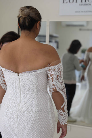 bride wearing off the shoulder long sleeve wedding dress