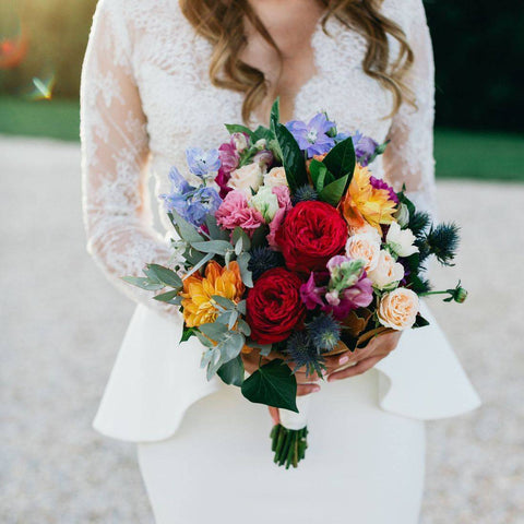 bridesmaid holding bouquet of colorful flowers