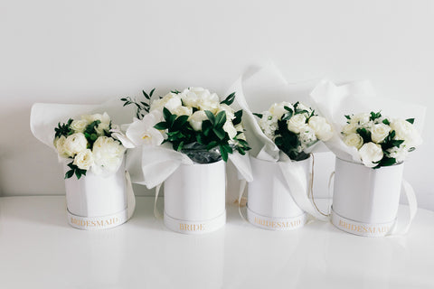 four plant boxes holding bouquets