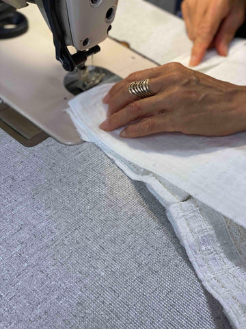 hands moving fabric through sewing machine