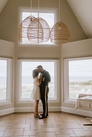 husband and wife dance and kiss in front of windows