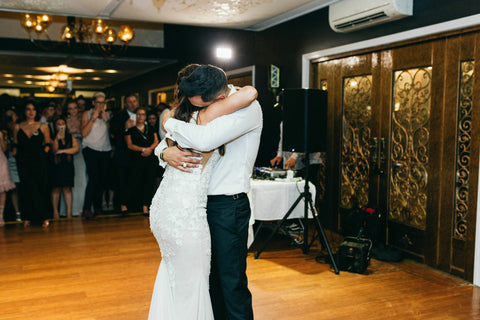 husband and wife hugging on the dance floor at their wedding during first dance