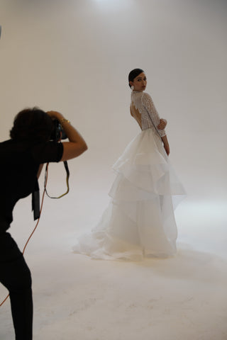 photographer holding camera taking pictures of model in wedding dress