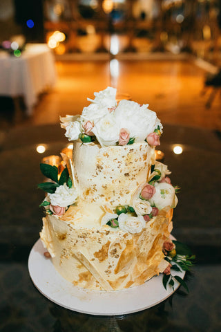 wedding cake on table with flowers on it