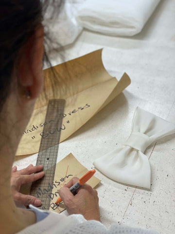 woman pattern making a wedding dress with ruler pen and pattern paper