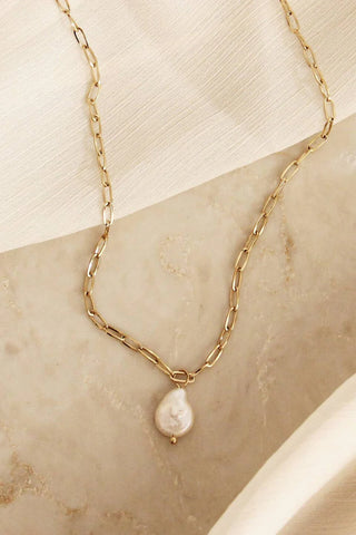 Maive Jewelry. Introducing the Baroque Pearl Paperclip Necklace by Maive. Adorn yourself with this luxurious piece featuring a beautifully natural baroque pearl, delicately hung on a simple 18k gold finish paperclip style chain.