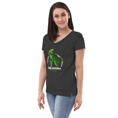Women's v-neck t-shirt features a T-Rex design in varying shades of green and white. The text on the graphic reads: Top line, OKLAHOMA. Middle Line, Tourism Information Center. Bottom Line, Erick. Shirt color in black.