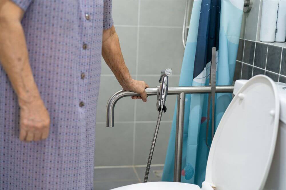 Asian senior elderly old lady woman patient open toilet bathroom by hand in nursing hospital ward