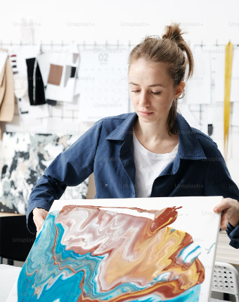 A lady artist holding a finished painting