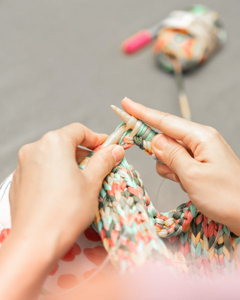 A lady knitting a cloth