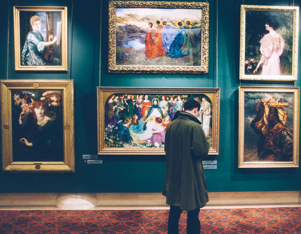 A man standing in front of paintings