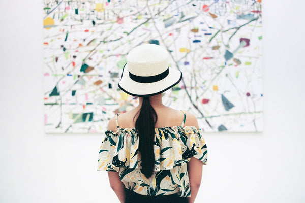 A photo of a woman standing infront of an abstract painting