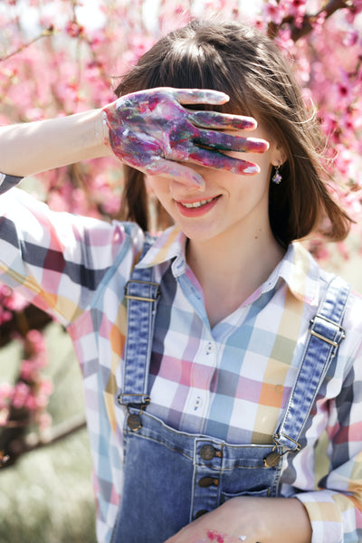 A photo of a woman wearing checkered shirt and an overall