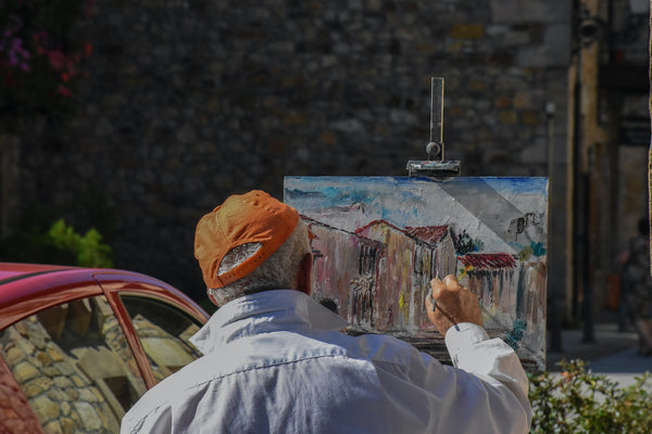 A photo of an elderly man painting