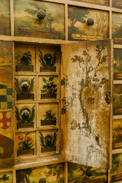 A photo of an old fashioned drawers with different paintings