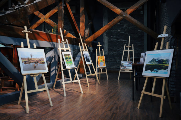 A photo of five assorted paintings on easels