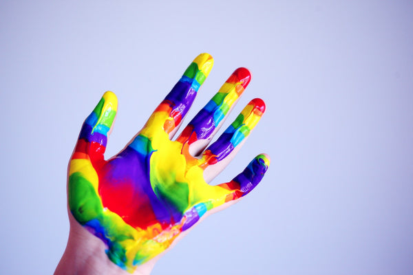 A photo showing persons hand covered with paints
