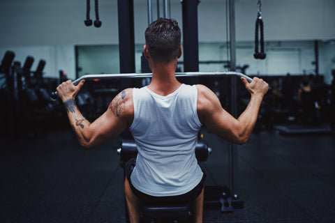 A man hitting his pull-down goals wearing on of his favorite workout t-shirts.