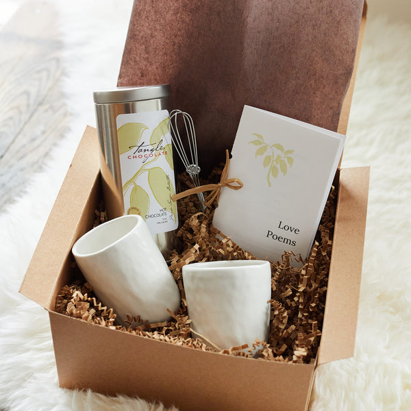gift box with two white handmade pottery mugs, a tin of Tangle hot chocolate, a booklet of love poems