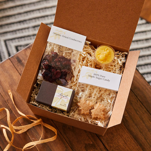 Gift box of Tangle Chocolate slivers, maple sugar maple leaf candy, organic cranberries, a bee-embossed beeswax tealight