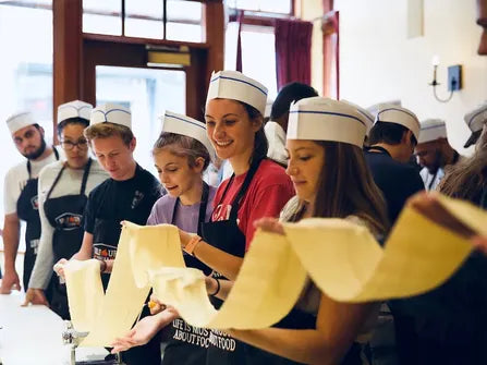 Cooking Classes for Groups | coworkers holding pasta dough