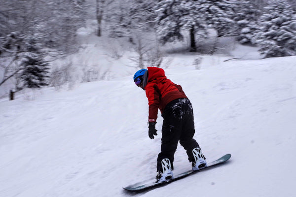 man in red skiing down a snowy slope