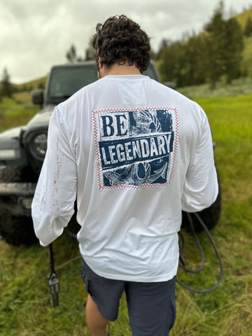 man walking away from camera in a field in a long sleeve tee that says Be Legendary