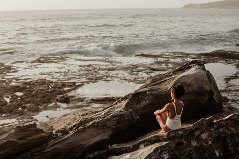 mujer biohacker meditandoen la playa