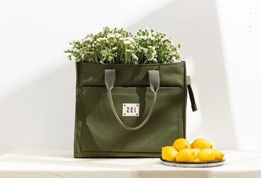 Green bag with flowers and lemons beside it