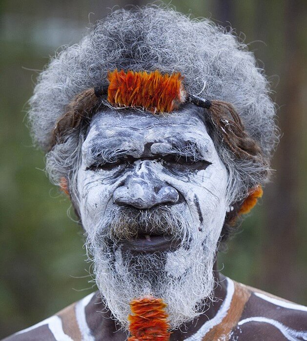 Image of Aboriginal man wearing white face paint putting white face paint  onto a young Aboriginal boy - Austockphoto