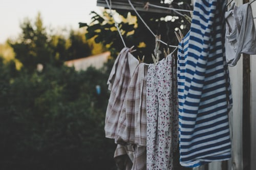 Freshly washed clothes hang drying on clothesline