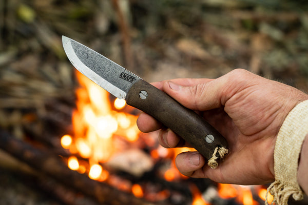 The Knafs Lulu fixed blade knife. Used knife in hand in front of a campfire