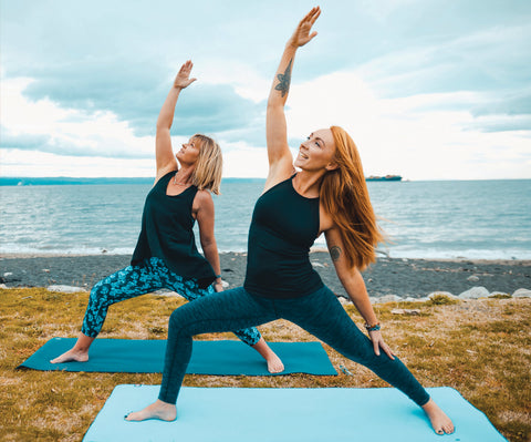 Two yogis practicing on the shore front | Eco Yoga Store