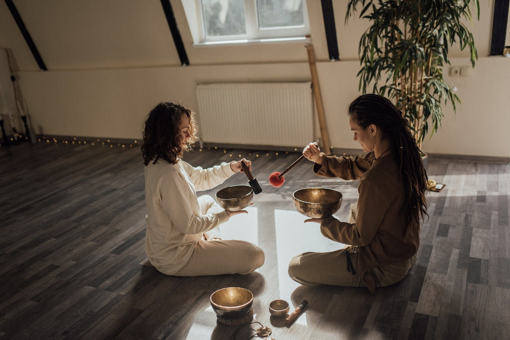 Two people using Tibetan singing bowls for meditation and yoga | Eco Yoga Store