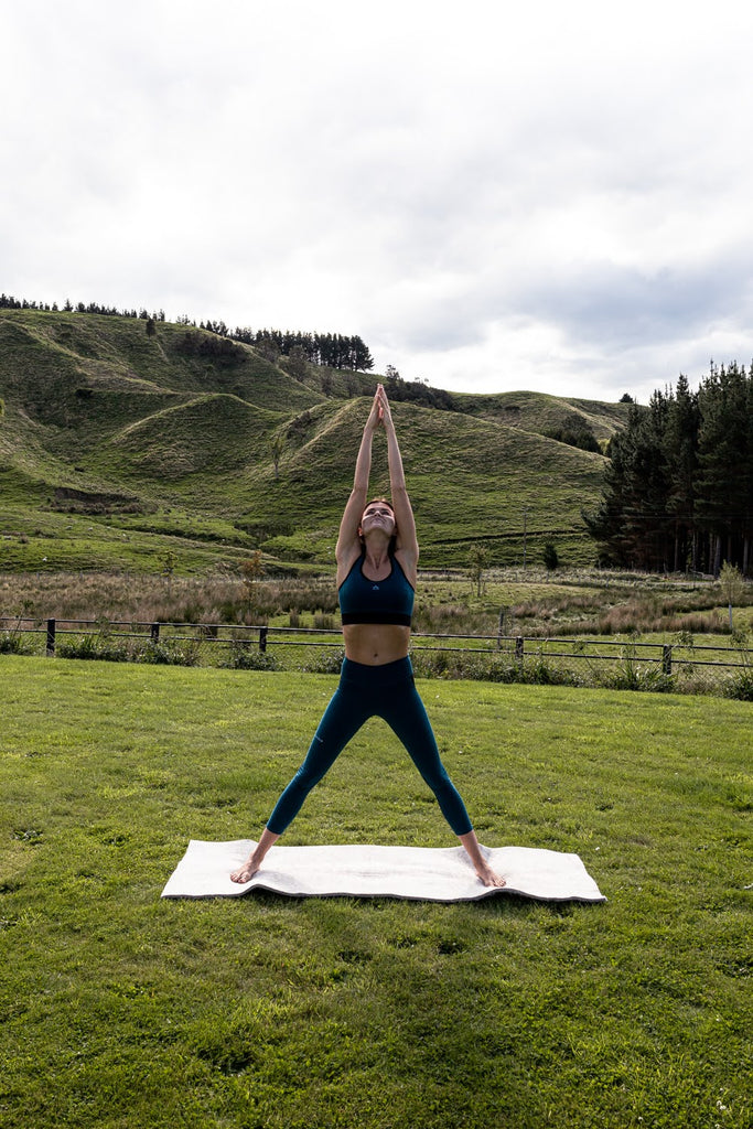 Yogi in a standing asana on her Move to Wool Movement Mat in a paddock | Eco Yoga Store