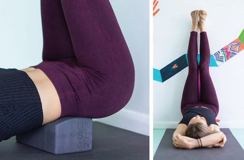 Manduka unBLOK supporting the lower back with body on th efloor and legs elevated 90 degrees against a wall - Manduka | Eco Yoga Store