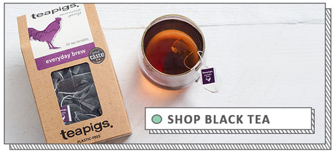 black tea in a glass cup next to the packaging