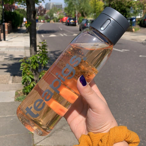 hand holding teapigs and Joseph Joseph bottle in front of London background