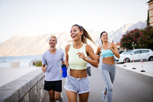 A group of healthy young people happily jog because they've overcome IBS 